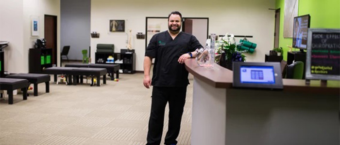 Chiropractor Plano TX Cyrus Laali Standing at Front Desk