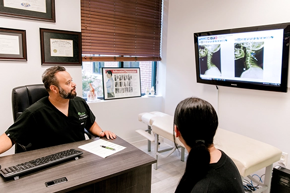 Chiropractor Cyrus Laali About Examining X-Ray With Patient